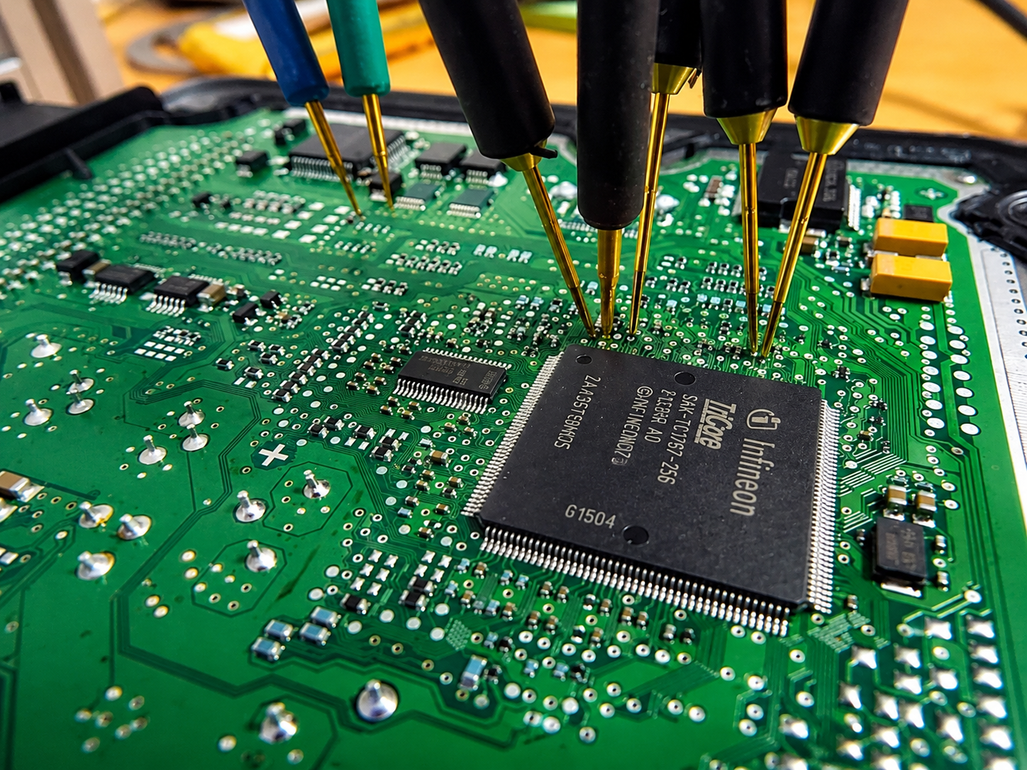 ECU-Platine auf der Werkbank mit Messspitzen an einem Infineon-TriCore-Prozessor